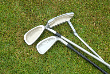 three golf clubs on grass