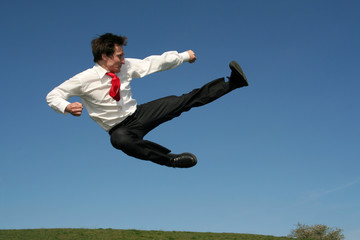 businessman doing a karate kick outdoors