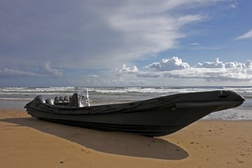 black boat against a blue sky