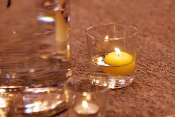 burning candle in water glass