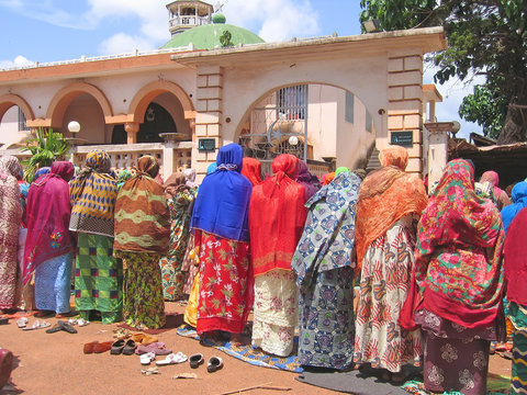 african woman praying with colored tissus, cameroon, africa