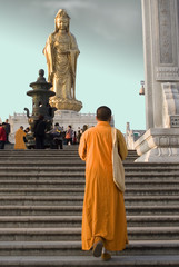 monk approaching statue of guan yin