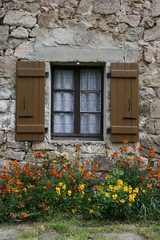 Fototapeta na wymiar fenêtre au-dessus d'un parterre de fleurs de giroflées
