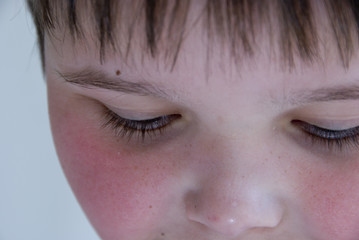 Obraz premium young boy looking down with his eyes almost closed