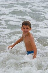 Fototapeta premium boy playing with ocean waves