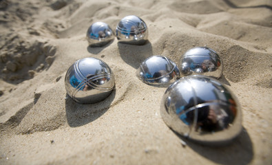 playing a ball game (boccie)  on the beach