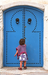 girl knocking on a blue door - tunisia