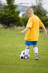 young boy learning how to play soccer