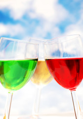 cocktails of various colors against blue sky
