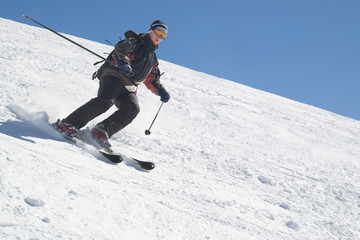 Fototapeta na wymiar narciarz z bieguna narciarskich na śniegu i błękitne niebo