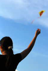 a girl flying a kite in the parks