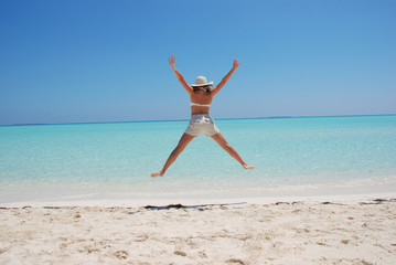 Fototapeta na wymiar woman jumping on beach