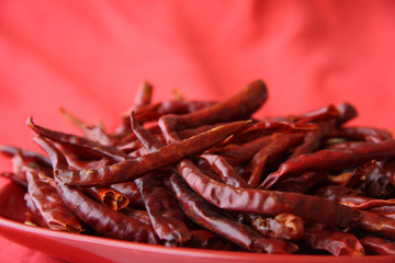red hot chilli peper pods on scarlett-red
