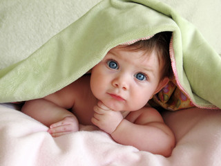 beautiful baby looking out from under blanket - obrazy, fototapety, plakaty