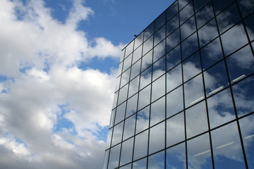blue sky and clouds reflected in the glass buildin