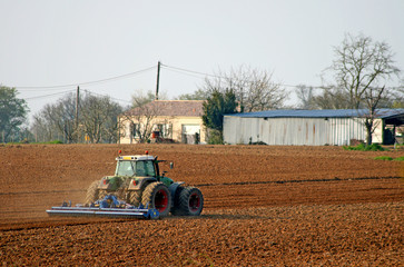Obraz premium tracteur labourant un champ dans la campagne