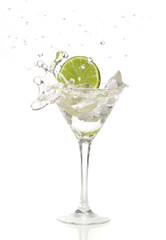 lime splashing into a cocktail glass