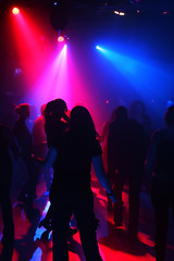 Fototapeta na wymiar tanzende menschen in blauen/roten discolichtern