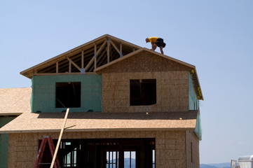 Fototapeta na wymiar worker on roof of new home