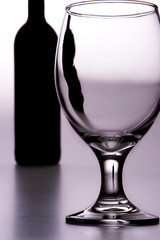 glass with bottle in background