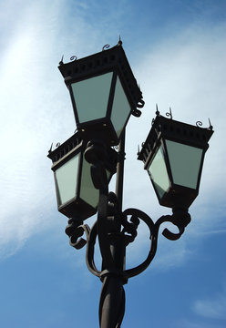 antique style lamp post against blue sky and cloud