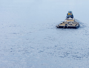 tug boat tow a barge upriver