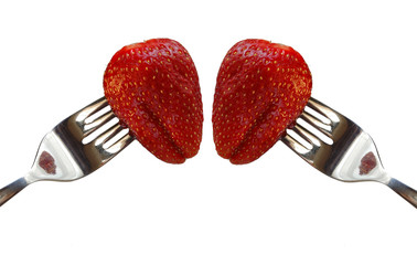 dos fresas rojas en tenedor