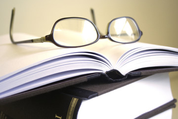 pair of glasses resting on open book