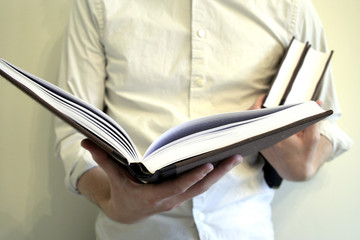 man holding and reading books