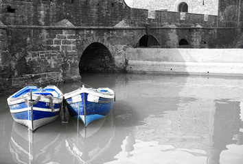 black and white harbour with two blue boats