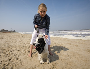 girl walking with her dog at the beach