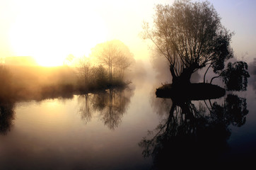 dramatic sunrise over a misty lake at dawn