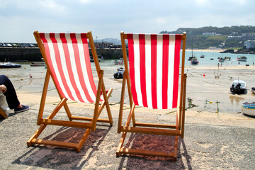 two empty deckchairs on the sea front, st. ives, u