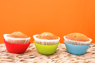 three vanilla muffins in plastic cups