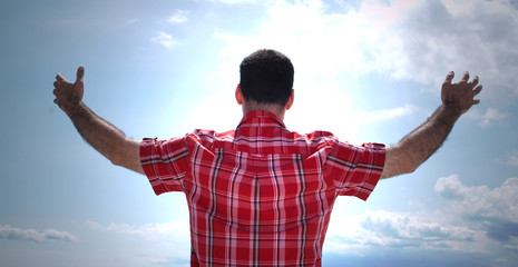 man with arms outstretched to the sky