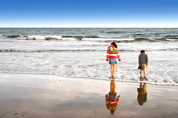 Young girl and brother playing by the beach