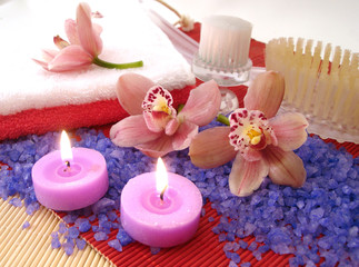 Obraz na płótnie Canvas Spa essentials (salt, towels, candles, brushes and pink orchids)