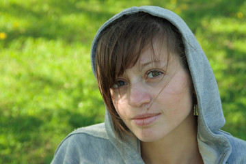 portrait of the young girl in hood on nature