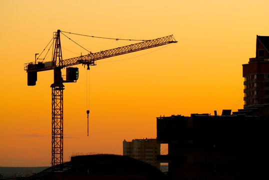 House building crane silhouettes against red evening skyset