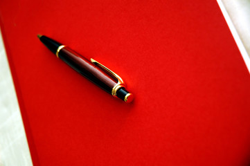 Red notebook and luxury pen