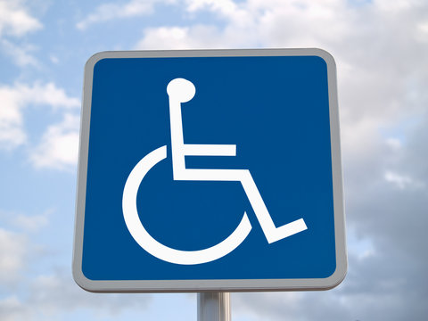 Standard disabled sign with clouds in the background
