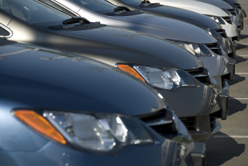 A lineup of new cars at a dealership. - obrazy, fototapety, plakaty