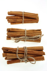 bunches of cinnamon sticks, tied by rope. soft focus.