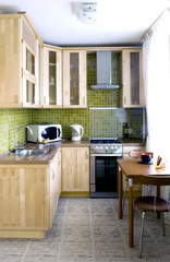 Kitchen - natural wood cabinets with glass and stone tiles