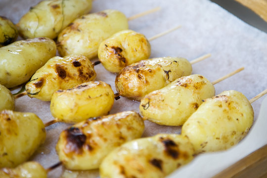 Grilled potatoes in wooden sticks, shallow focus