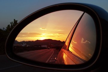 reflection seen through car side mirror - sunset