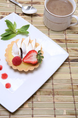 A delicious lemon dessert tart with coffee