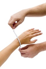 Two male hands puting a diamonds strap in a woman's arm