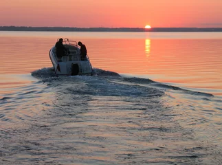 Foto auf Acrylglas Wasser Motorsport Schnellboot segelt in den Sonnenuntergang