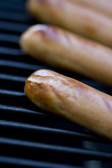 summer bbq  hotdogs on the grill  shallow depth of view 